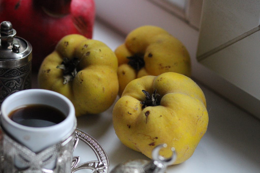 Three quinces on a coffee table