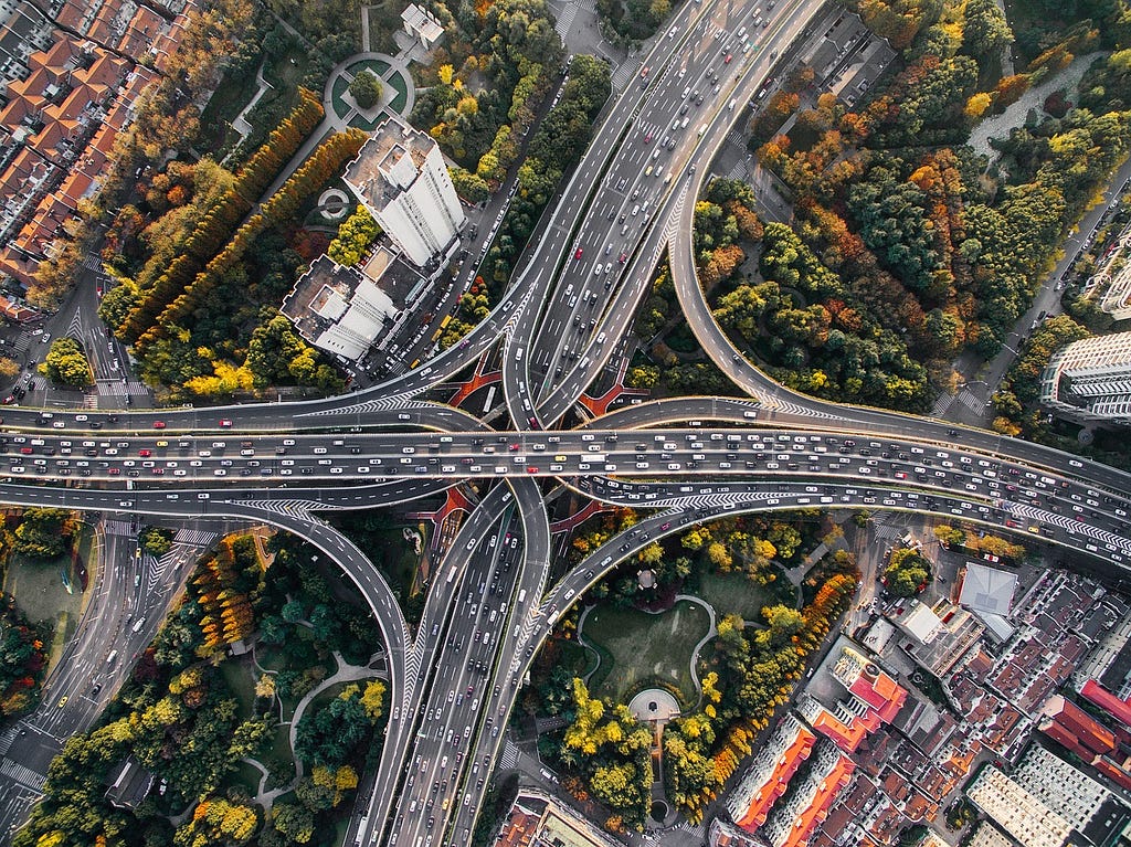 Birds eye view of a 4 way highway interchange as a representation of infrastructure that makes the world go.