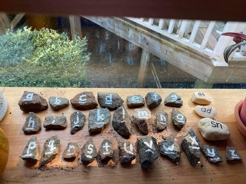 A photo of letter manipulatives made from rocks.