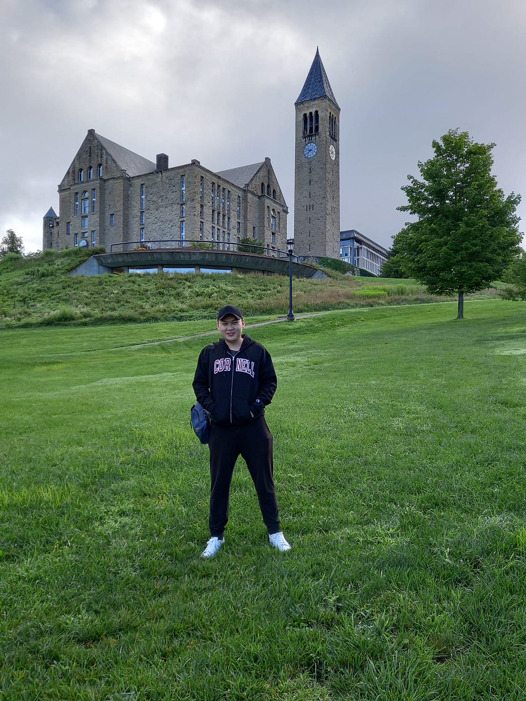 Patrick standing in front of the Cornell University