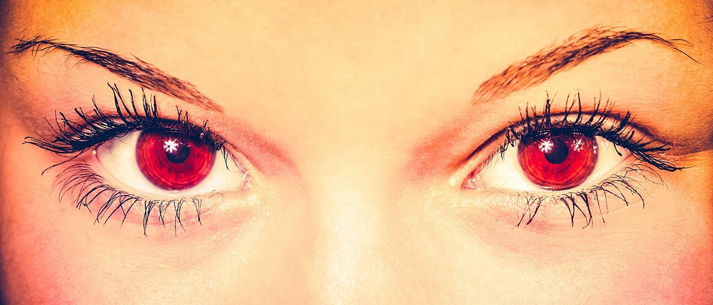 Just the eye section of a woman’s face. Eyes are red.