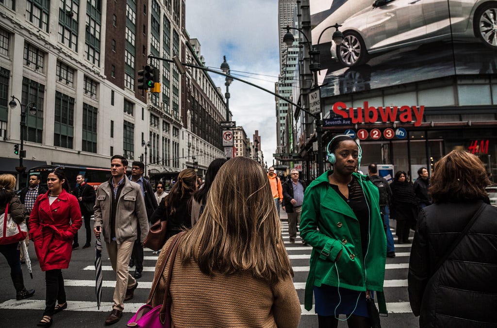 A person walks down a crowded New York City street.