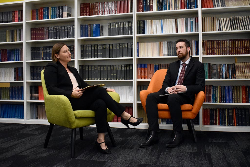 Sawyer Kemp and Cameron Hunt McNabb sit on two colorful couches while engaging in conversation.