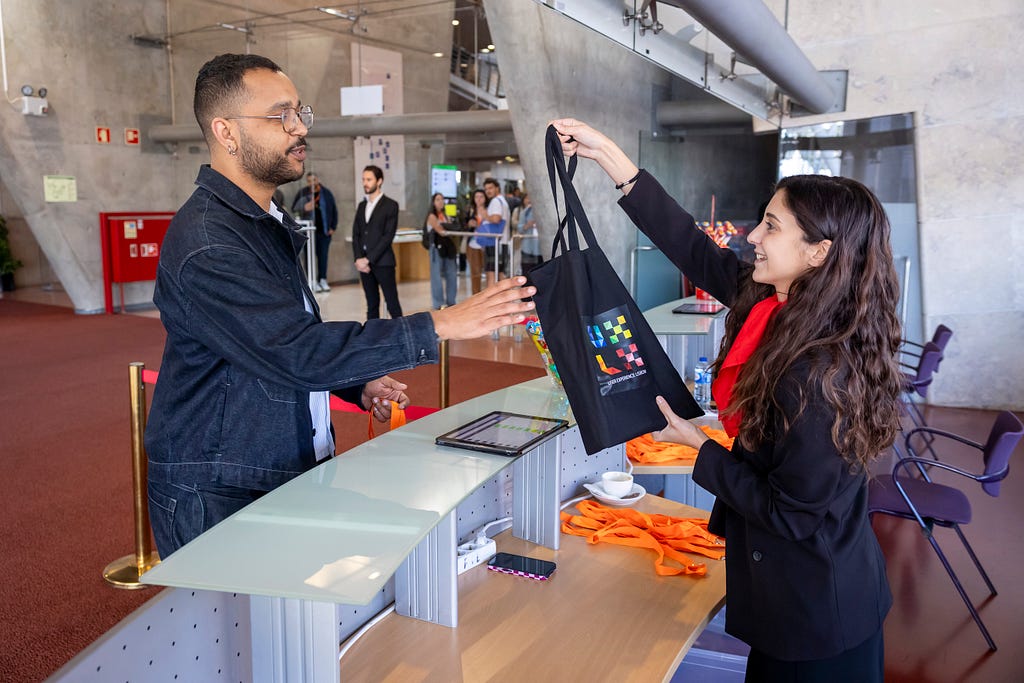 An attendee at the check-in desk receiving his welcome kit.