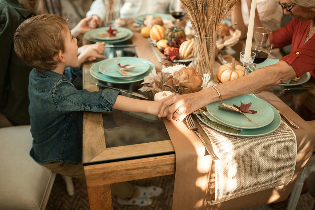 family holding hands at Thanksgiving dinner