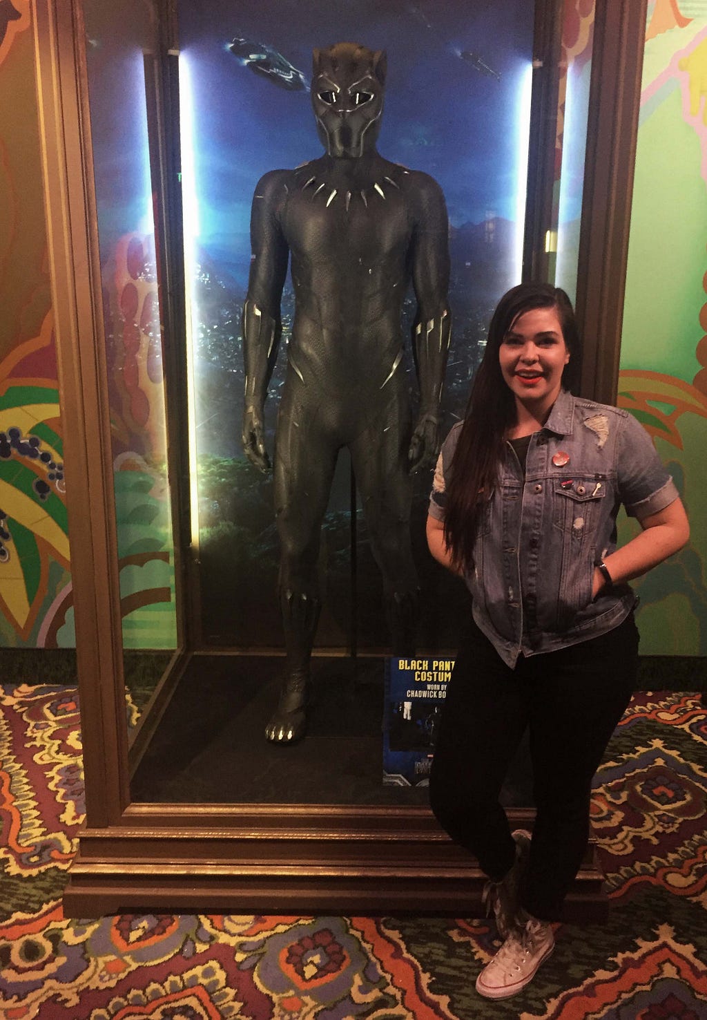 Kate Murphy standing with a Black Panther suit on display during the movies opening