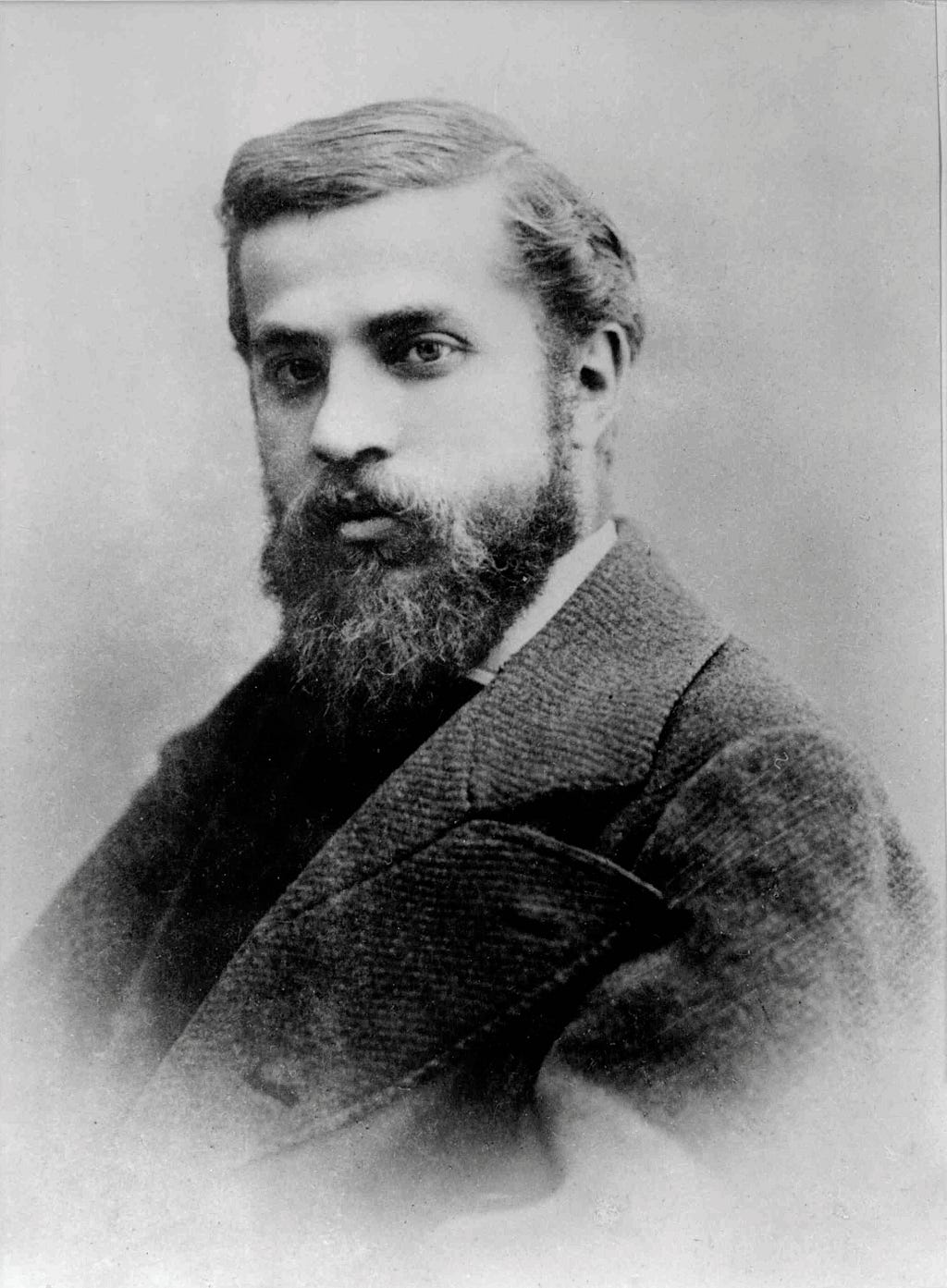 A black and white portrait of Antoni Gaudí.