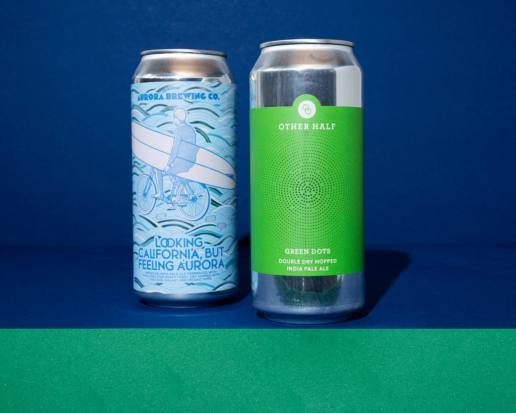 Two beer cans side-by-side from Aurora Brewing Company and Other Half that are examples of rich designs that use restraint in color palette and subtle pattern.