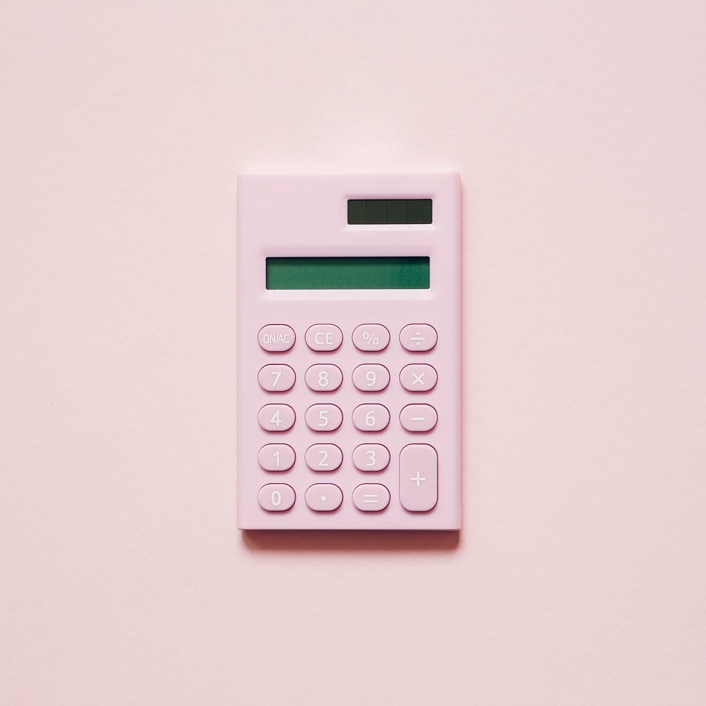 Image shows a pink calculator with a blank screen.