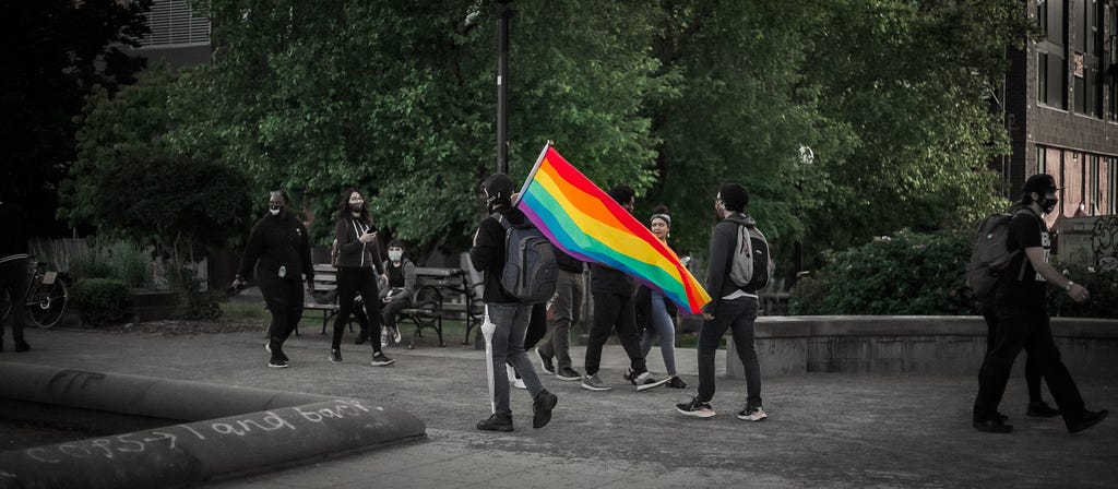Man walking with rainbow flag.