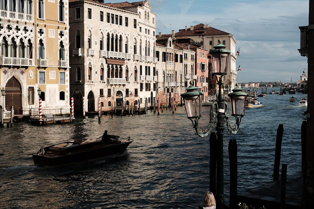 Venice canal: buildings in sunlight, boat in the shadows