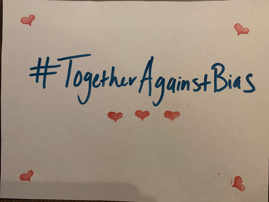 Picture of a handwritten sign “#TogetherAgainstBias” with hearts around it. I promise, it’s cute.