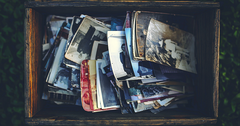 A top view of a wooden box full of vintage photographs