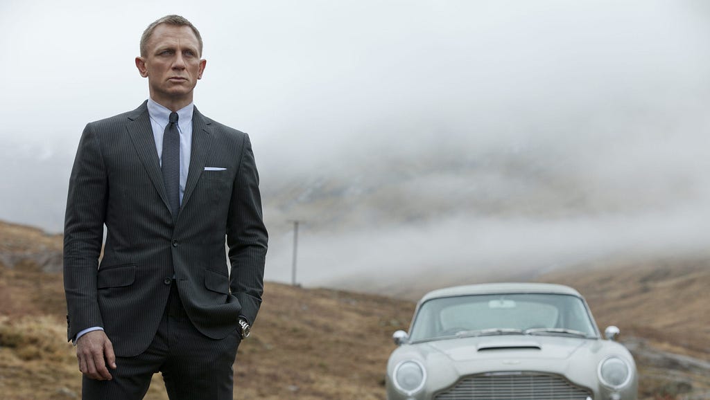 James Bond stands in front of his Aston Martin DB5 in Scotland