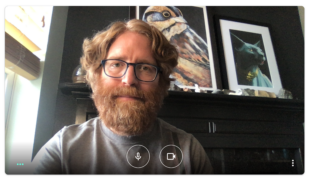 A screenshot from Google Meet, featuring a head and shoulders shot of the author with some art in the background