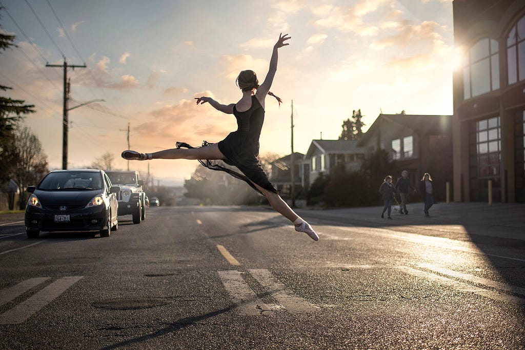 Ballet dancer leaping high in the street