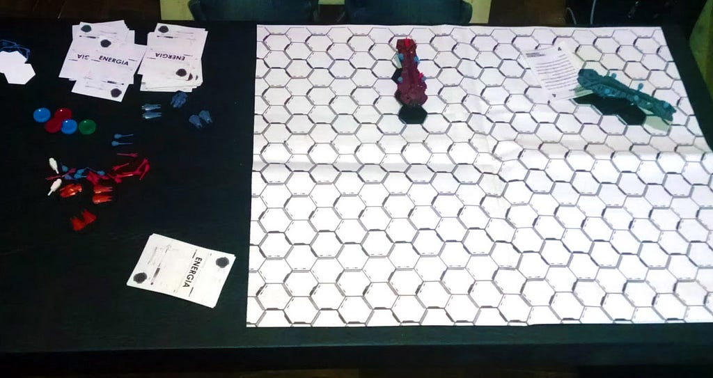 A crappy photo of an early playtests showing the layout of the board as well as a pile of components to the side.