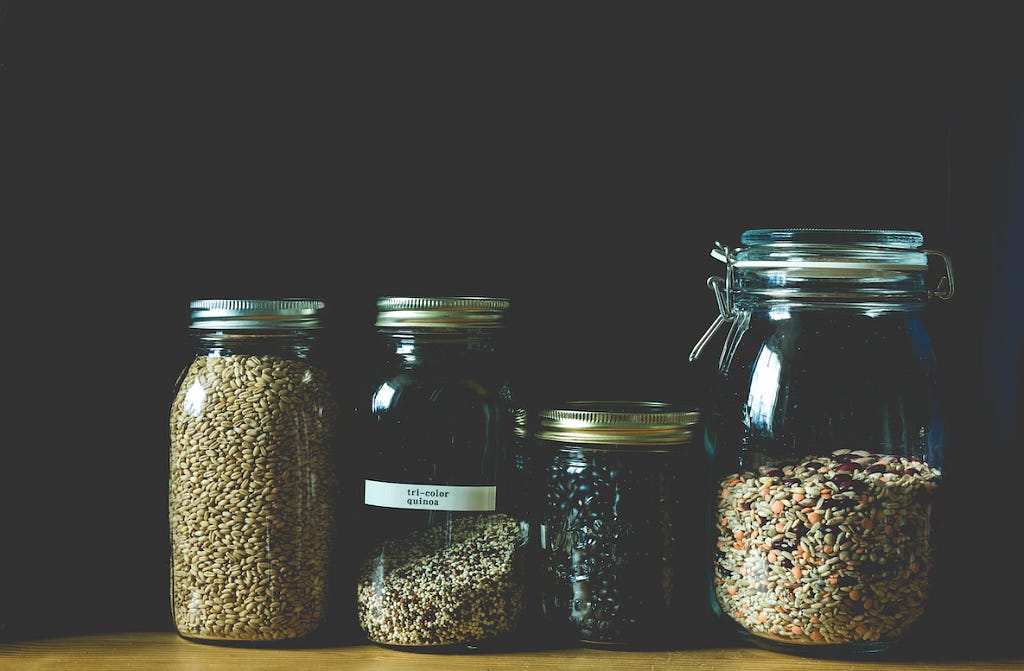 Four glass jars filled with colorful quinoa, showcasing a nutritious and versatile ingredient.