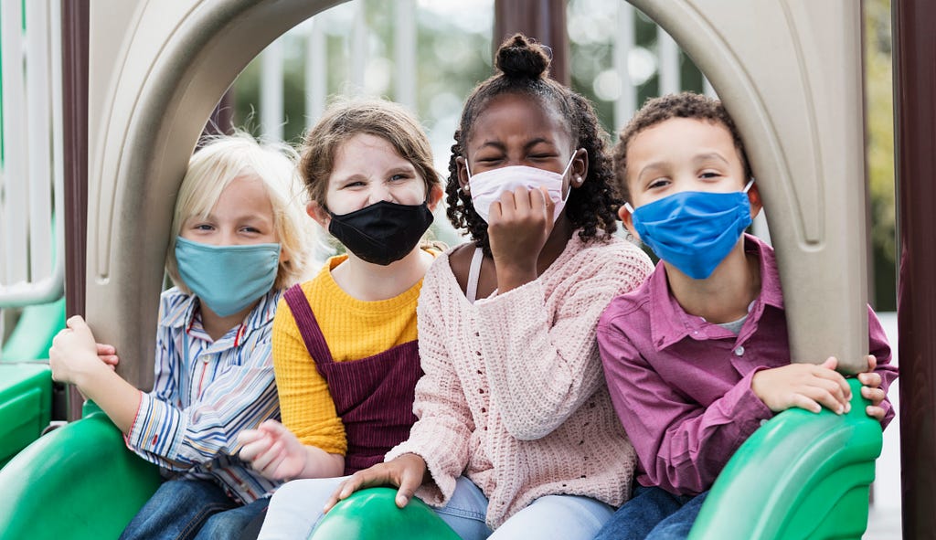 Children on playground wearing face masks
