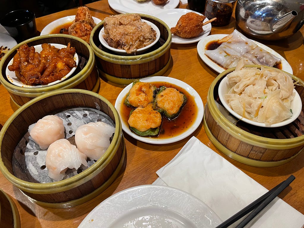Orders of seafood and dim sum on a wooden table
