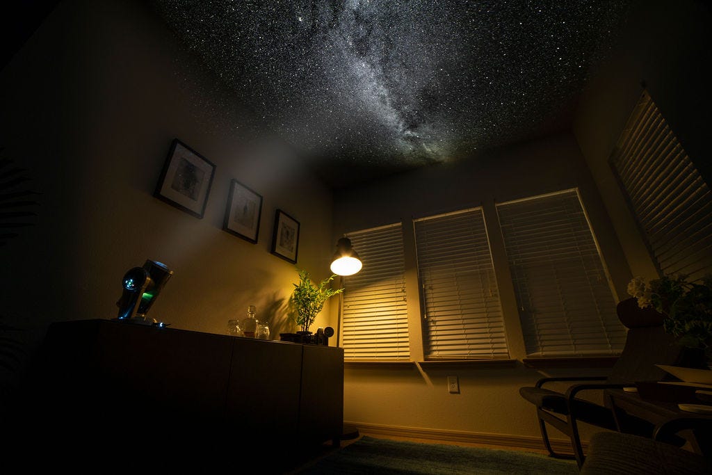 Dark Skys DS1 Home Planetarium projecting the Milky Way Galaxy onto the ceiling of a dimly lit living room.