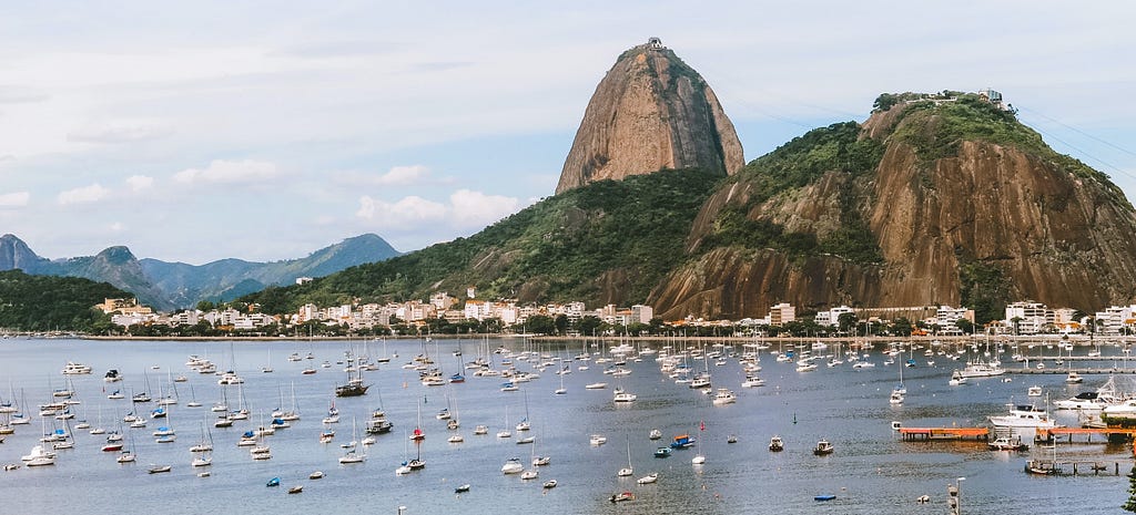 The image shows boats in Guanabara Bay and the Sugarloaf mountain in Rio de Janeiro, Brazil.