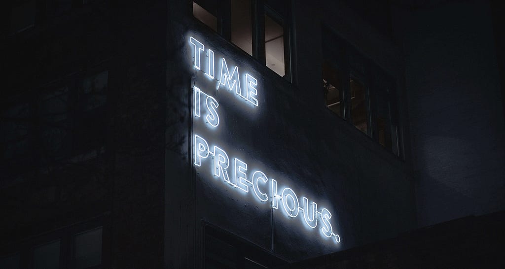 neon text on a building saying time is precious