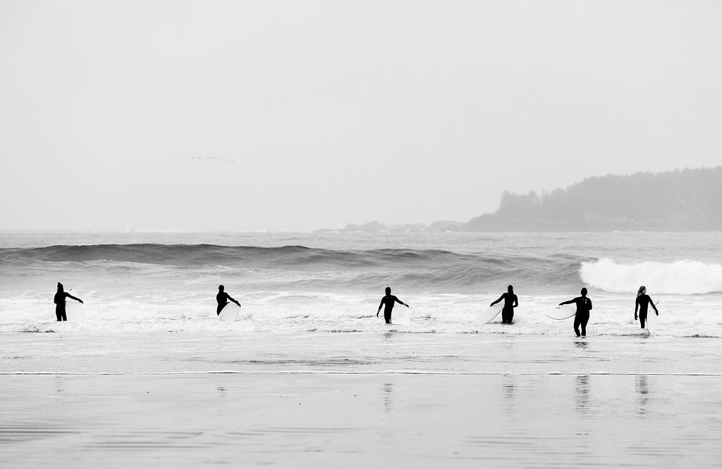 Surfers walking into the water in Tofino