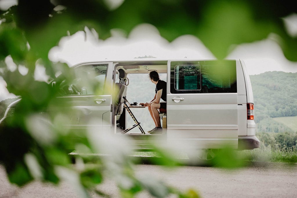 Man working on laptop in campervan