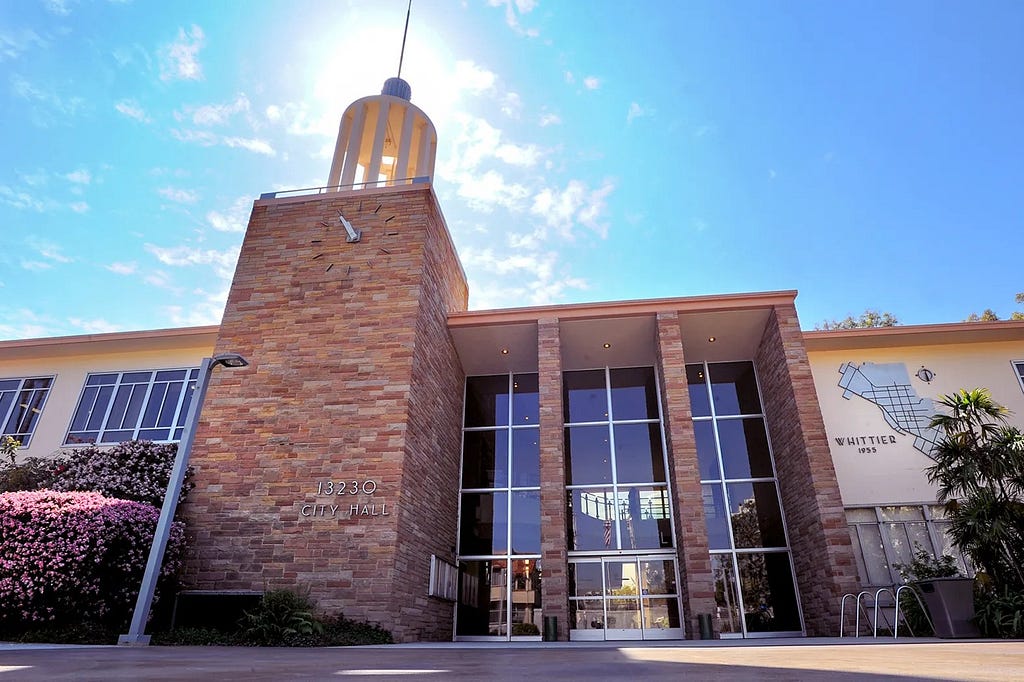 An image of the City of Whittier city hall building against a backdrop of a blue and sunny sky.