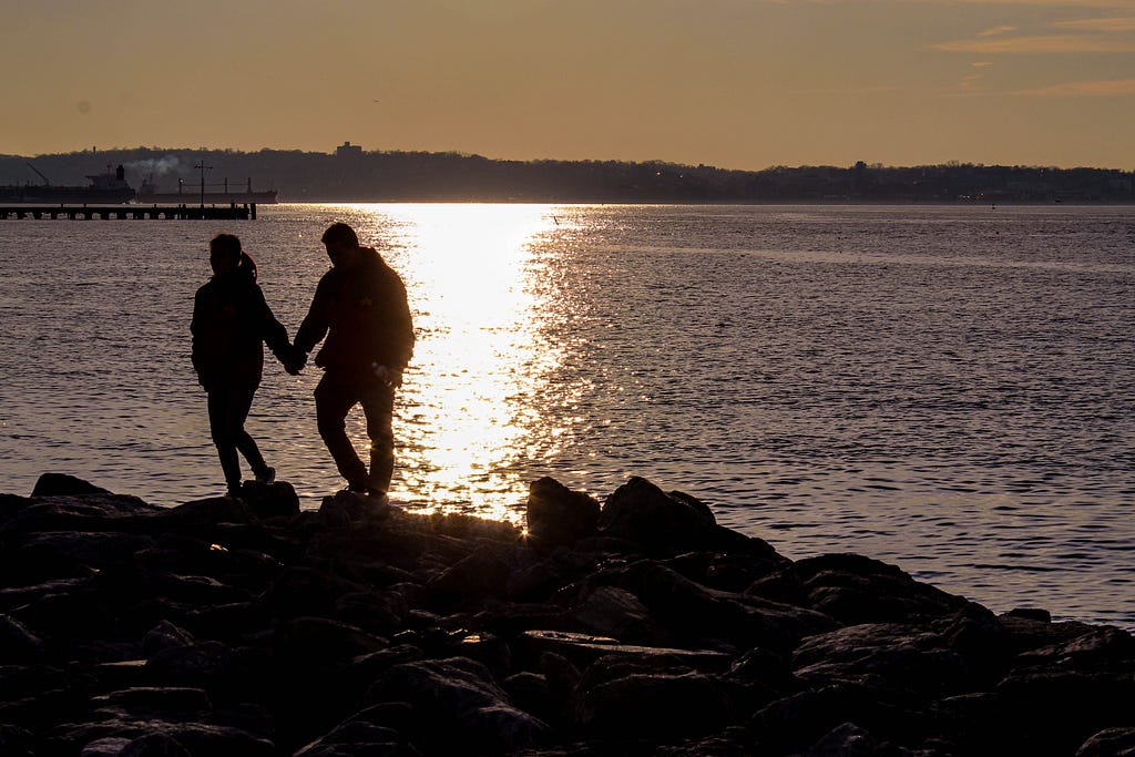 Couple holding hands on coast of Brooklyn, New York