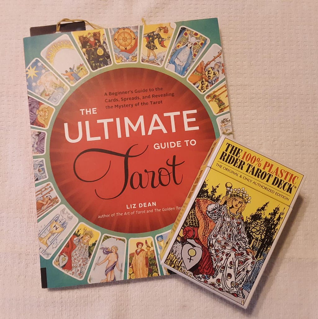 A deck of Rider-Waite-Smith tarot cards sits atop a tarot guidebook