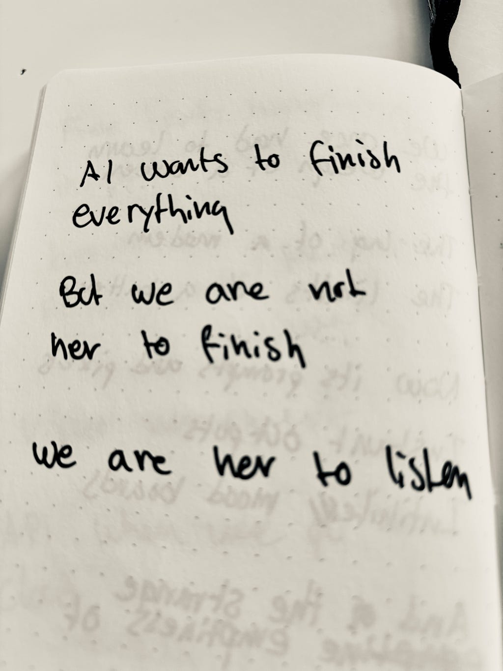 Picture of a handwritten poem in a small notebook: Ai wants to finish everything. But we are not here to finish. We are here to listen.