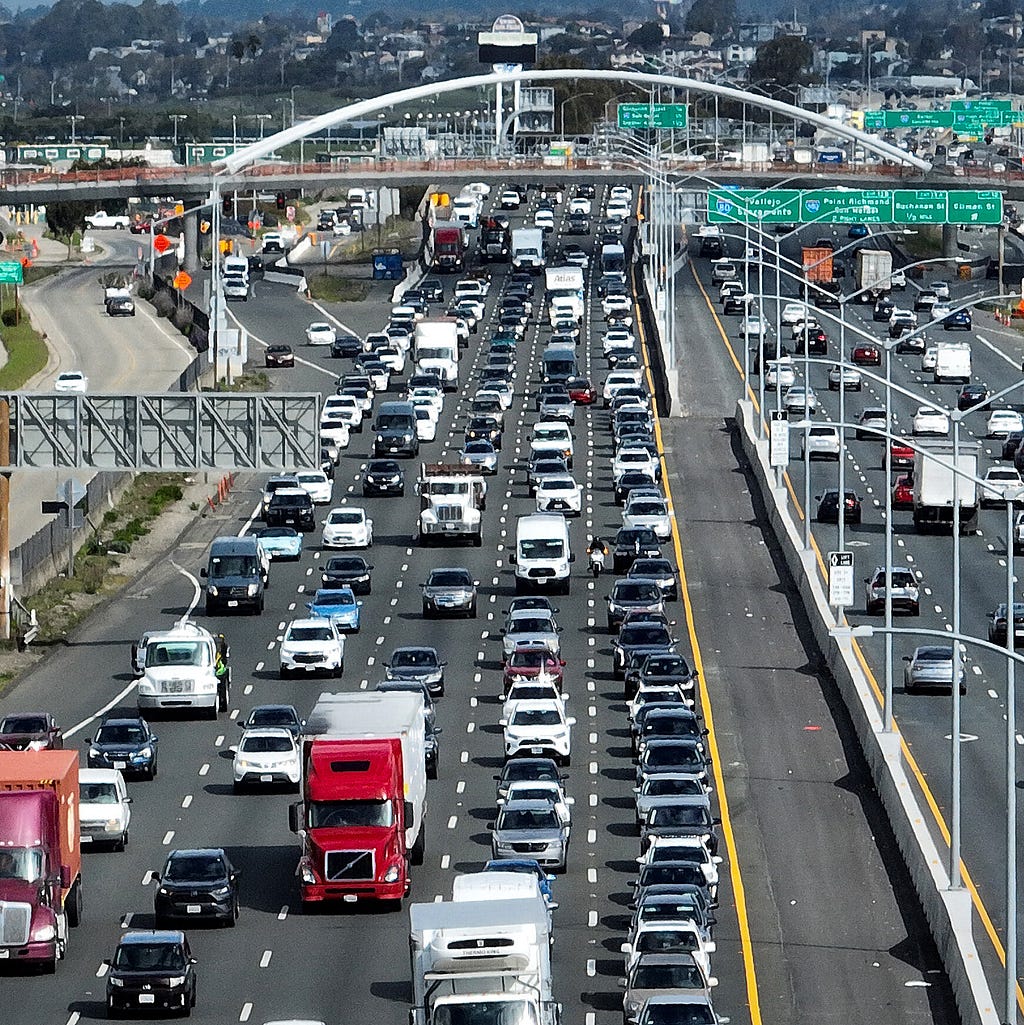 Vehicles driving on the highway. Some ICE (Internal Combustion Engine) and some EVs.