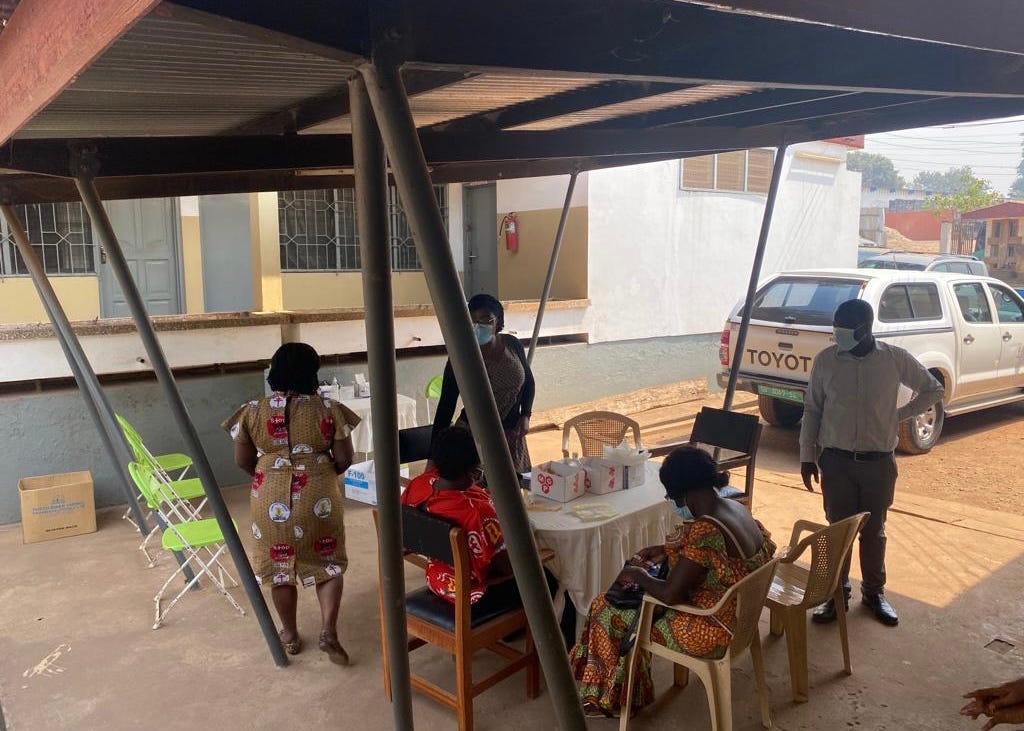 Five people gather around a table at a vaccination clinic.
