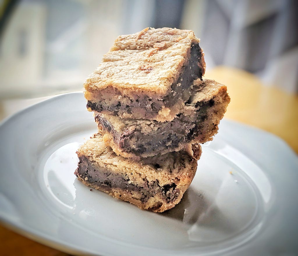 A stack of blondies with a thick chocolate layer in the middle