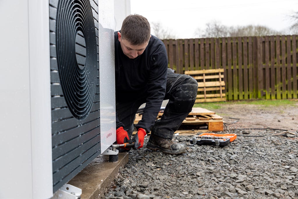 Image shows a heat pump installer working at a domestic property in Glasgow.