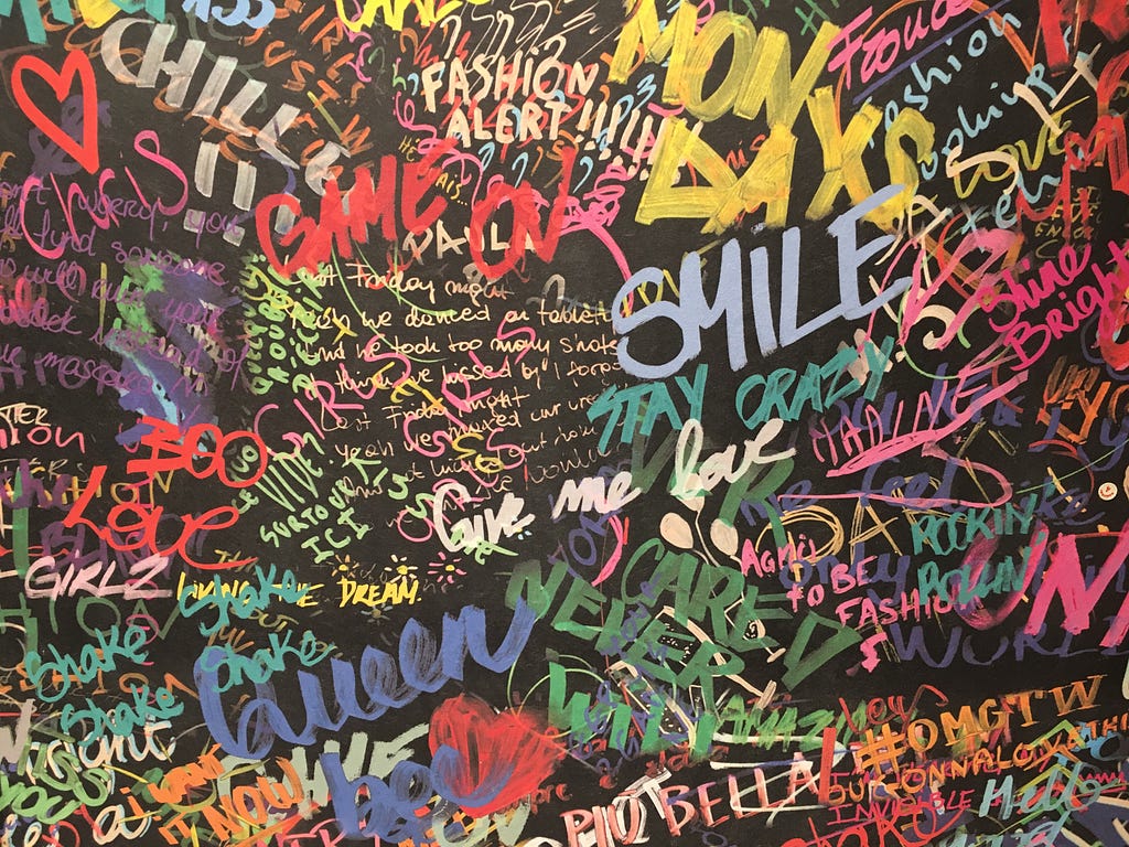 Black wall with colorful graffiti words