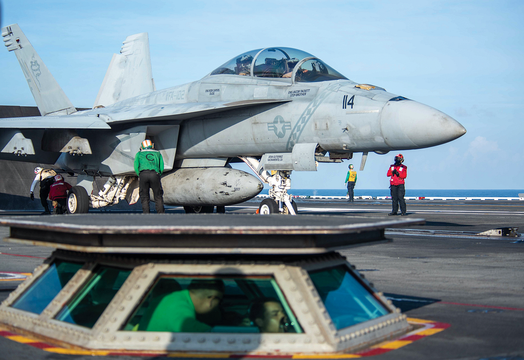 Photo of a fighter jet on an aircraft carrier.