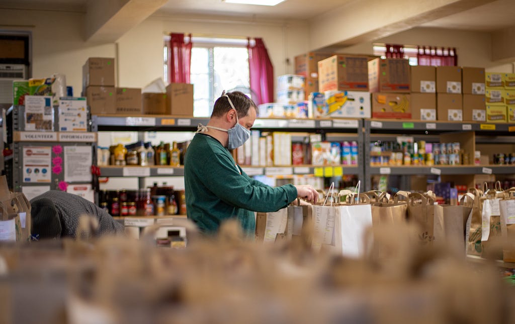 Man packing bags in food bank