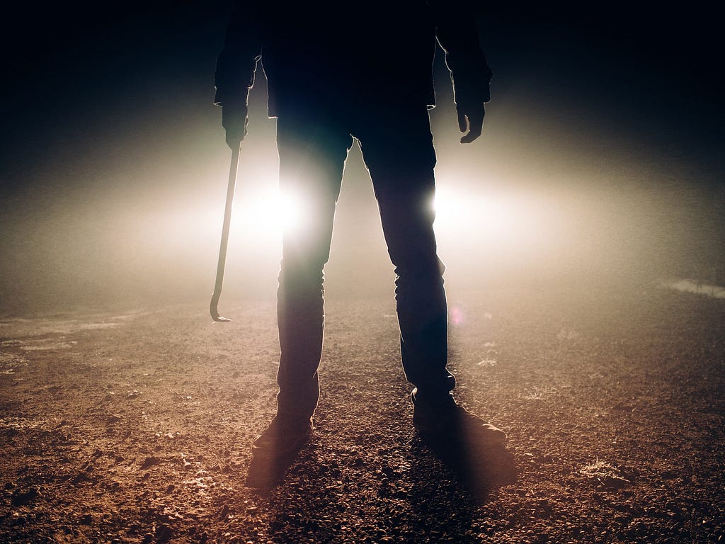 Killer standing in the road with a weapon in his hand
