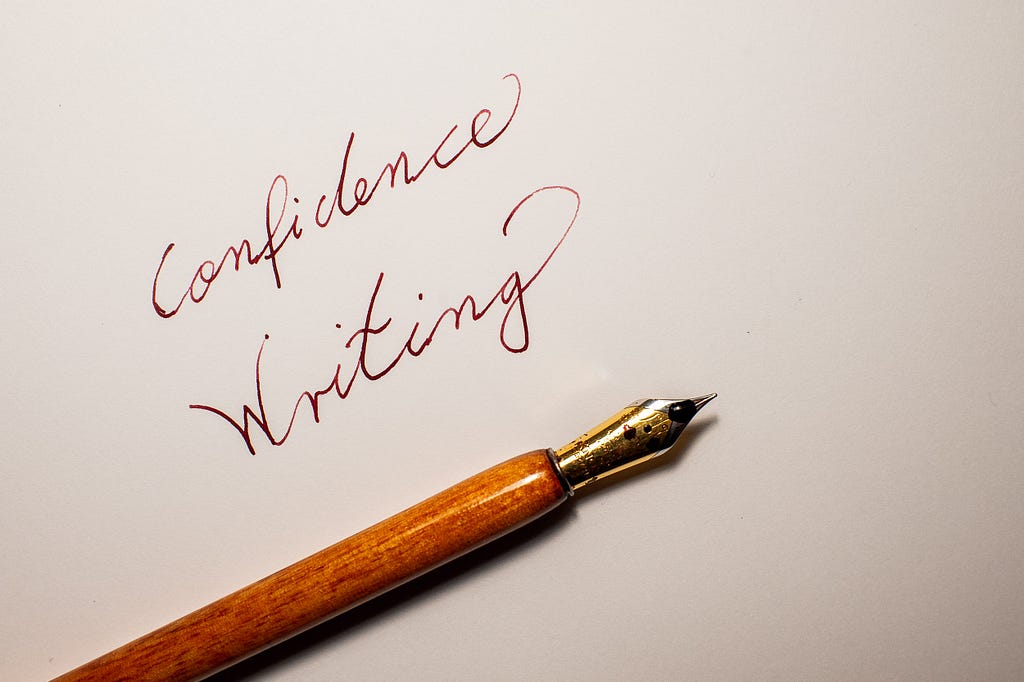 Confidence Writing: a sheet of paper with a dip pen and the words confidence writing written next to the pen in red ink. Oberhausen, Germany, November 25, 2023.