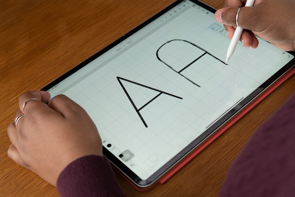 An image of an iPad with the letter A drawn in two styles.