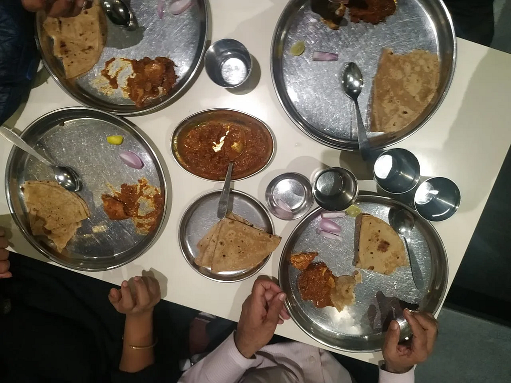 Top view of a hotel table with 4 people having Indian dinner