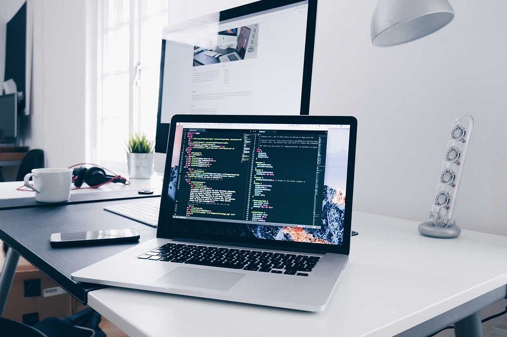 laptop on a desk with code