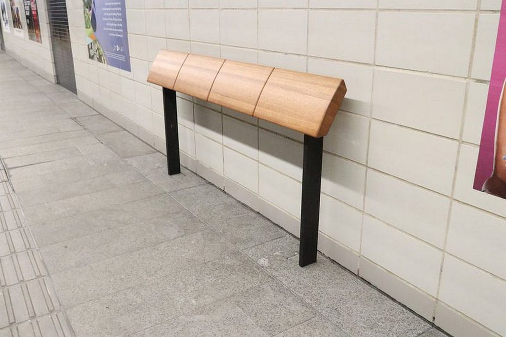 A bar with a very slanted base intended for leaning on in the NYC subway