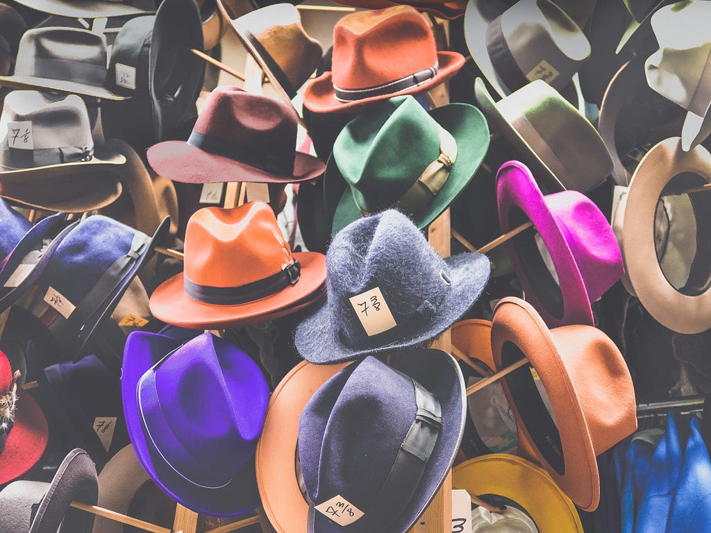 Variedades de chapéus dispostos em prateleiras.