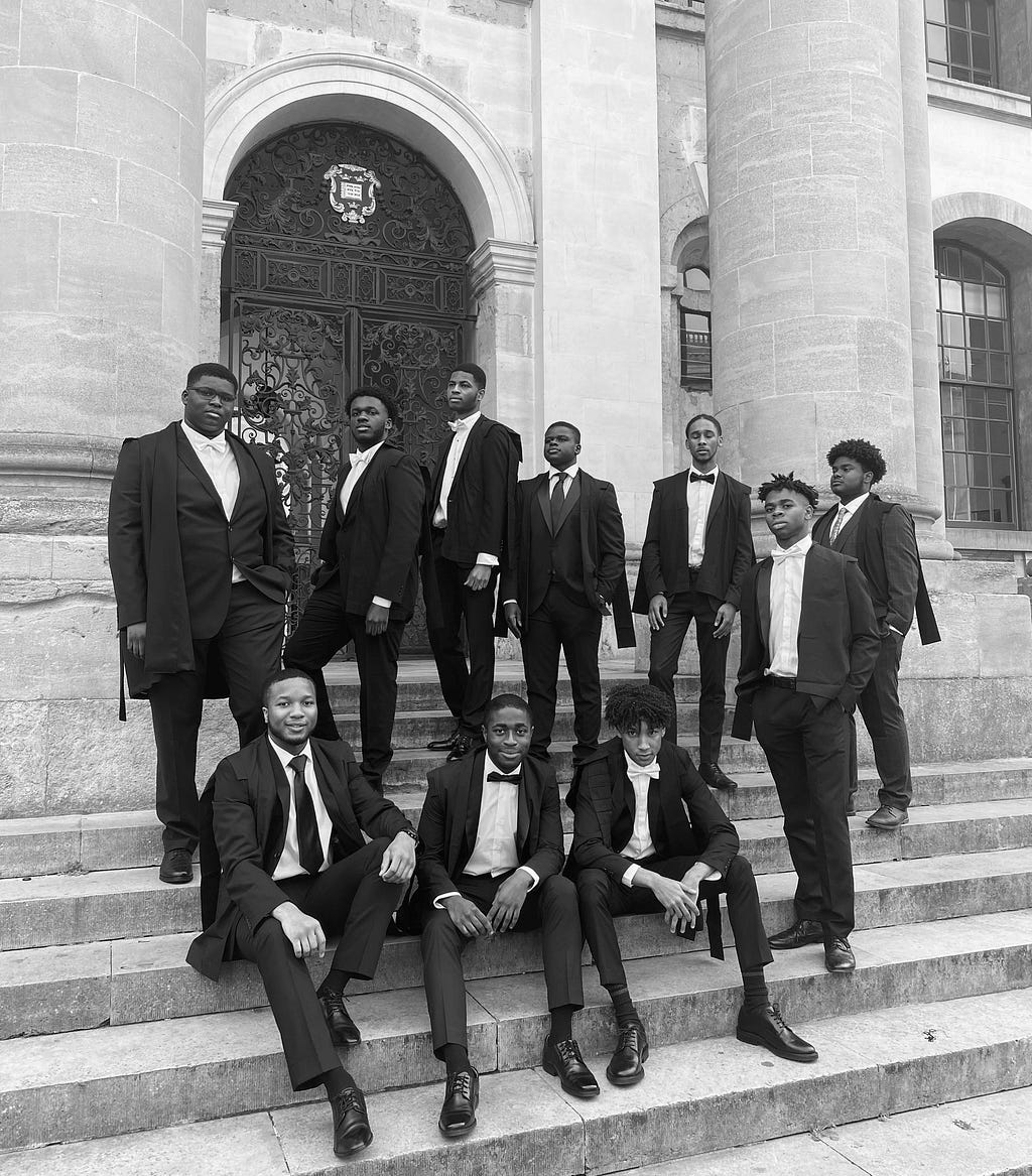 10 Black students stand on the steps of the Clarendon Building