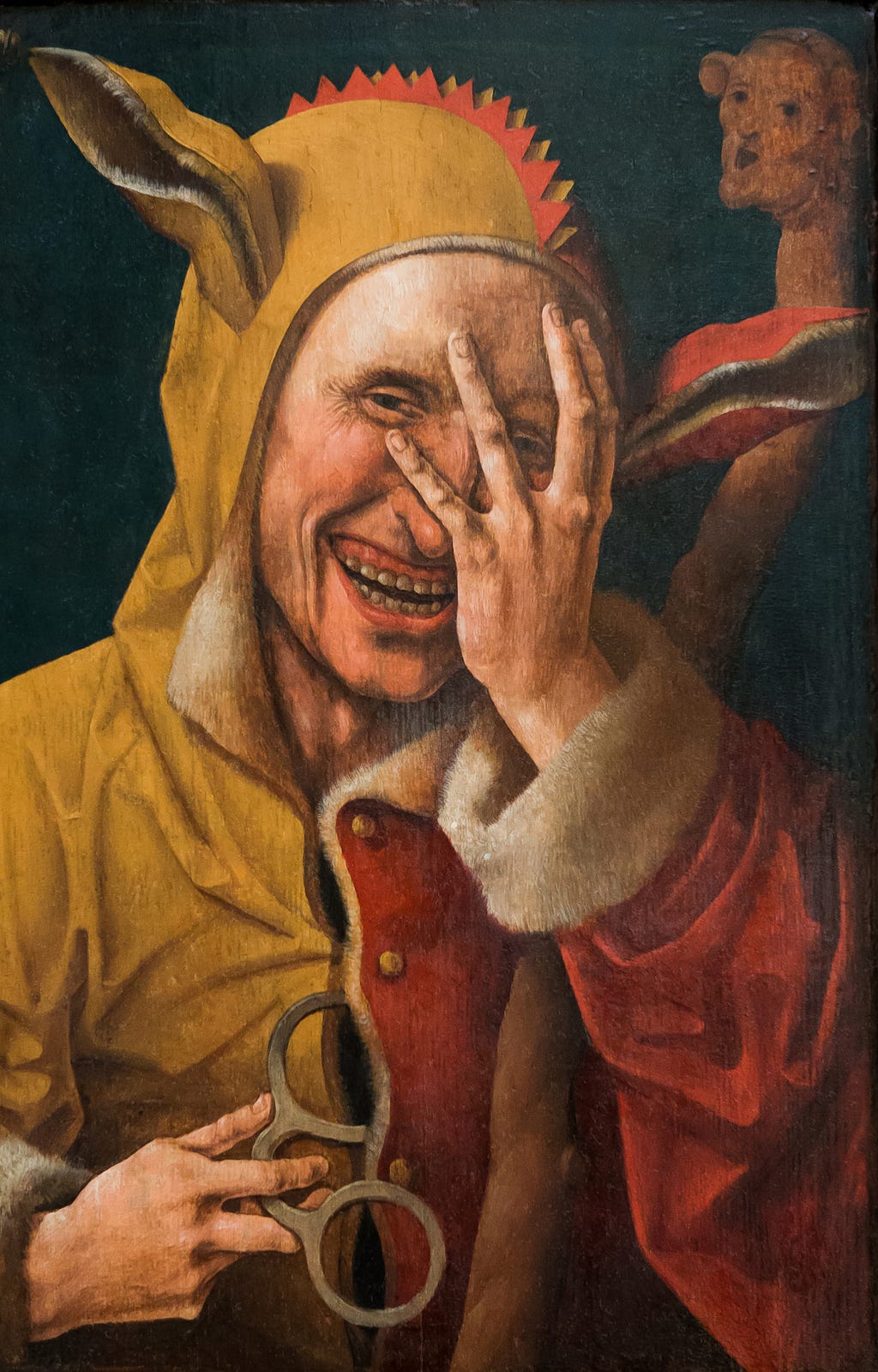 1500 CE oil painting of a medieval jester. (The Laughing Fool by Jacob Cornelisz van Oostsanen (?), Davis Museum in Wellesley, Massachusetts, USA)