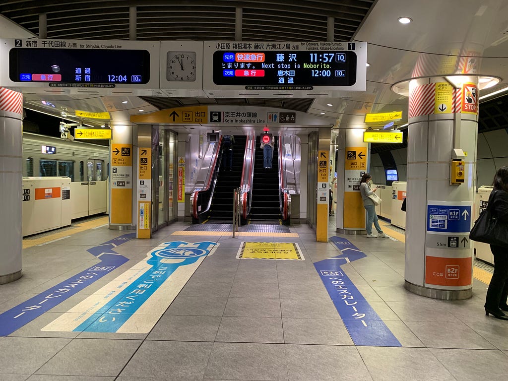 Tokyo train station exit arrow signs everywhere — the floor, pillars, and ceiling.
